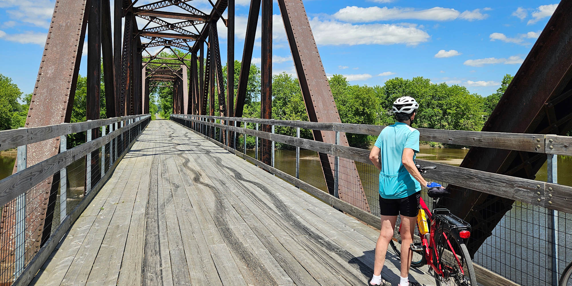 Guest pausing on a bridge on bike trail in Vermont